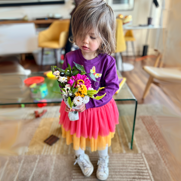 Customer-littlegirl-tulle-sweatshirtDress-holdingflowers